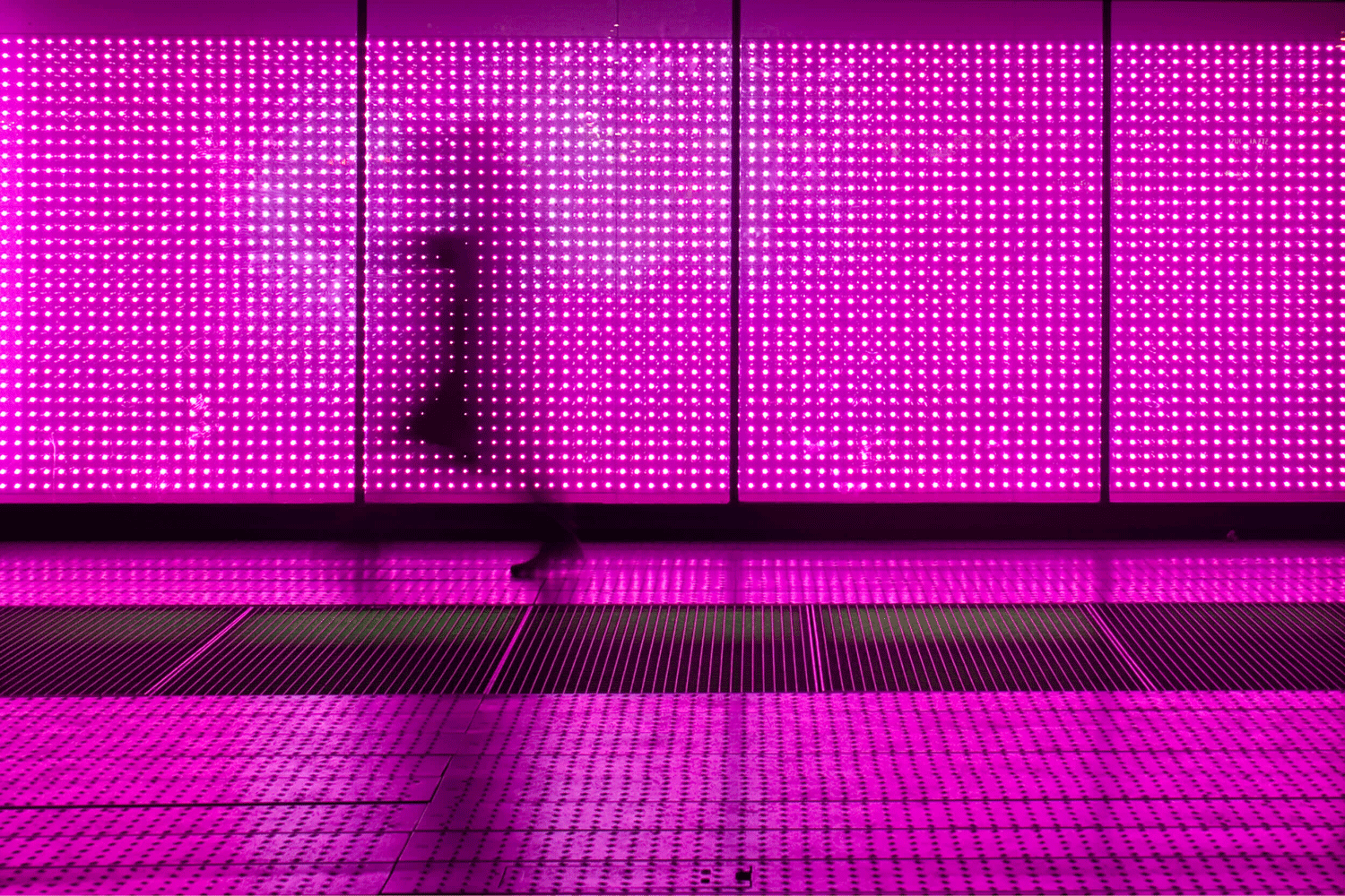 person walking in front of a light wall 
