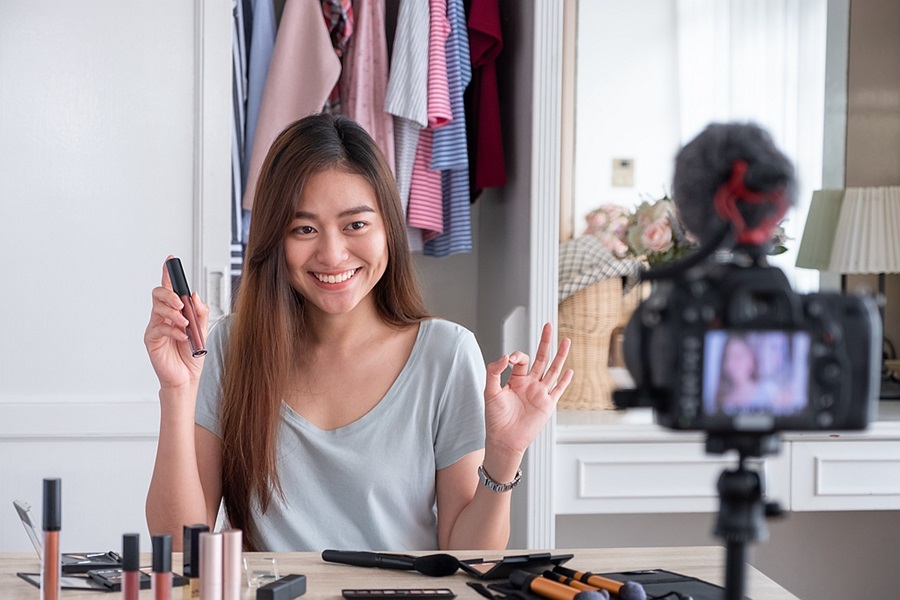 East Asian live streamer working in front of a camera