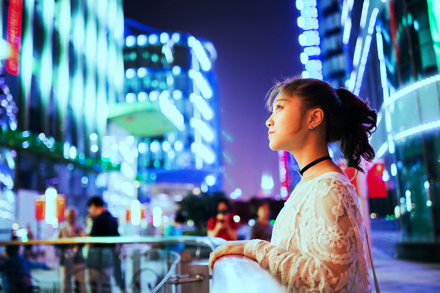 Una mujer observando las luces de los edificios