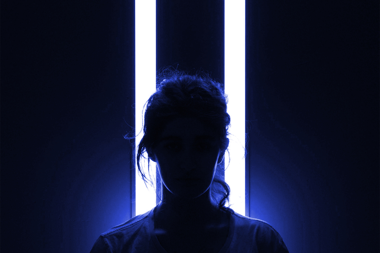 silueta de mujer en fondo oscuro y con luz