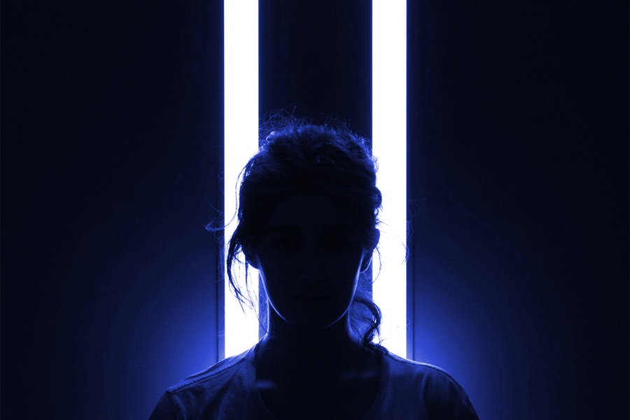 silueta de mujer en fondo oscuro y con luz