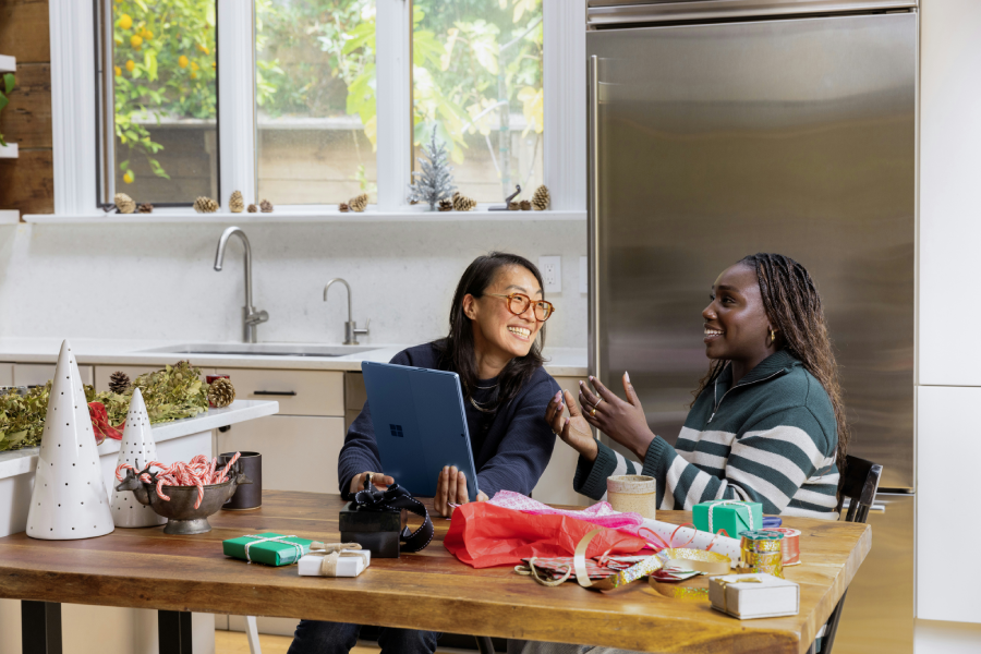 Two women sat in a kitchen laughing - The Serious Business of Humour 